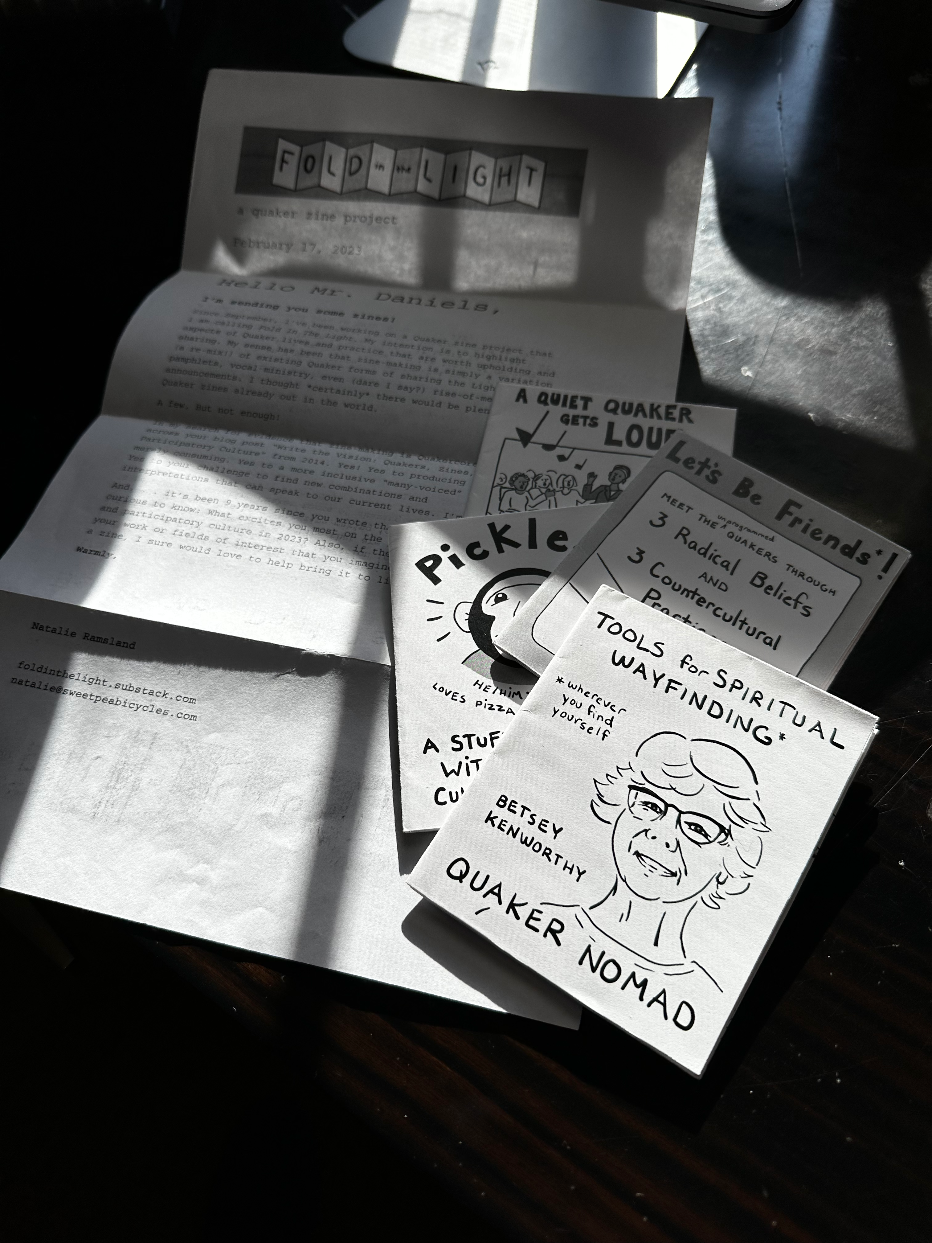 Image of a letter and four small zines sitting on top of the letter